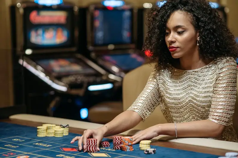 Woman placing stacks of chips on a gaming table – JLPUB bonuses