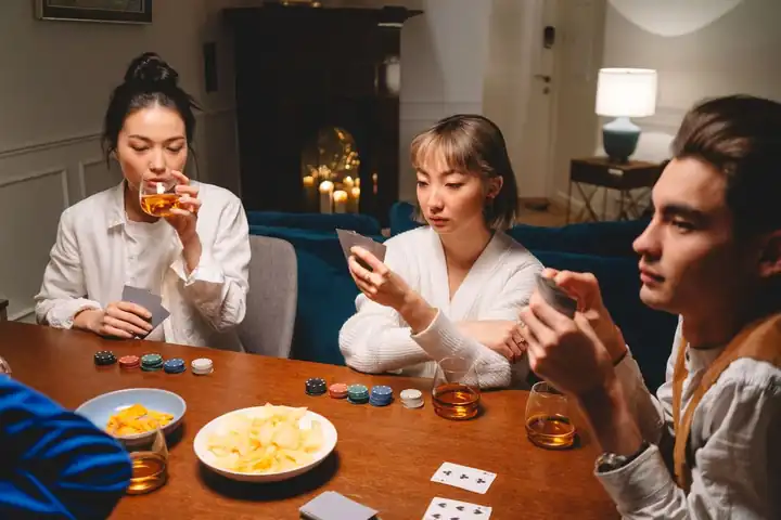 Filipino-Asian friends playing poker with chips and snacks – JLPUB poker