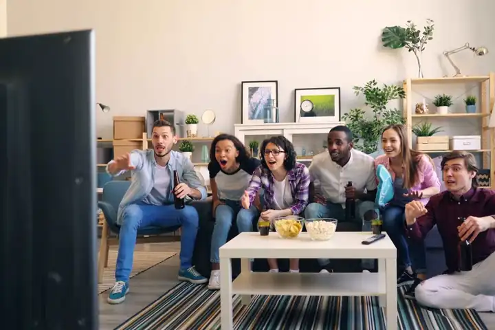 Group of friends cheering a game on TV – JLPUB sports betting